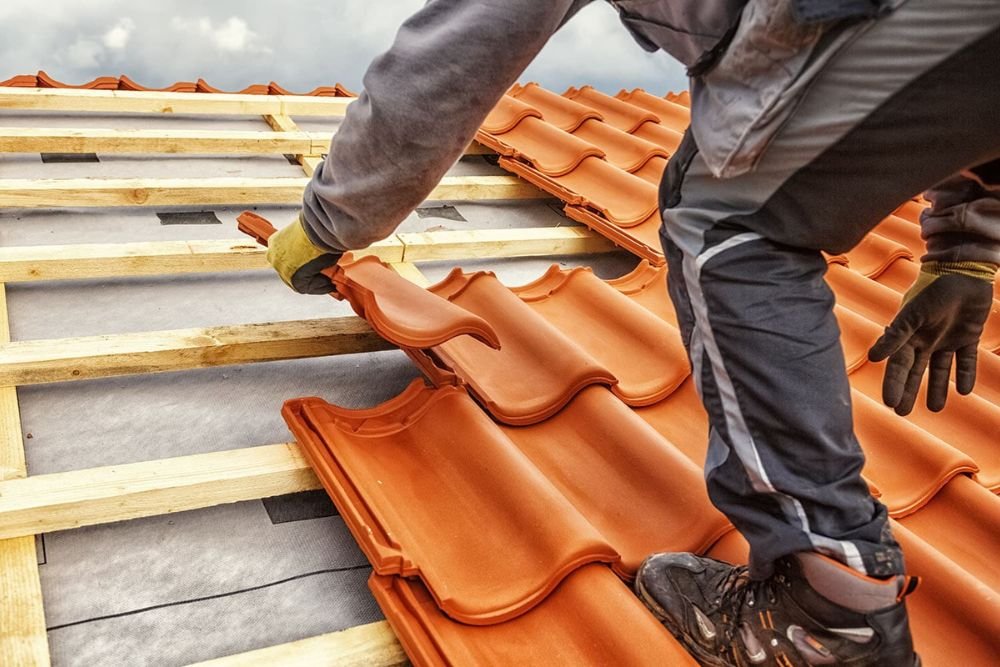 A skilled worker is installing roof tiles, representing quality roofing service in Tacoma.