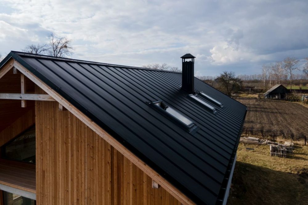 A residence with a metal roof and wooden siding, highlighting Skylight Service located in Tacoma, WA.